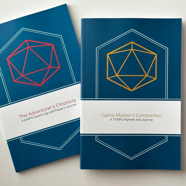 Two softcover books, slightly overlapping; covers show the Adventurer's Chronicle and the Game Master's Companion 